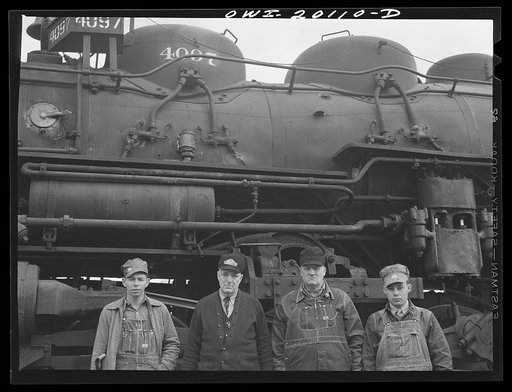 Wellington, Kansas. An Atchison, Topeka and Santa Fe Railroad crew posing in front of their engine before pulling out of Wellington for Waynoka, Oklahoma. Left to right: D.C. Quivey, head brakeman; D.B. Wallingford, conductor; B.F. Hale, engineer; and fireman Walker