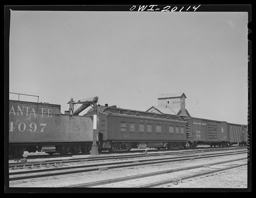 Harper, Kansas. An Atchison, Topeka and Santa Fe train taking water enroute to Waynoka, Oklahoma. Behind the engine is the division superintendent's business car