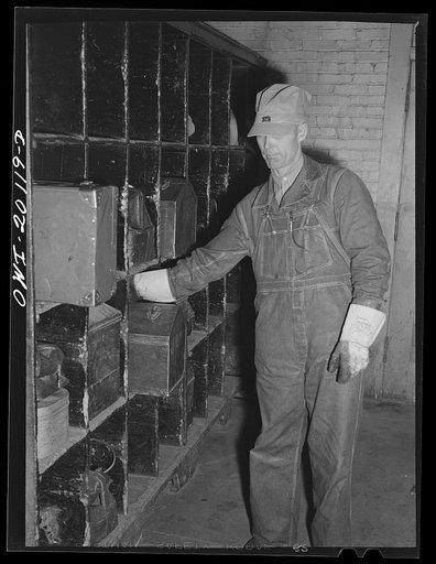 Untitled photo, possibly related to: Wellington, Kansas. Atchinson, Topeka and Santa Fe engineer going off to work stops in the locker room for his tool kit