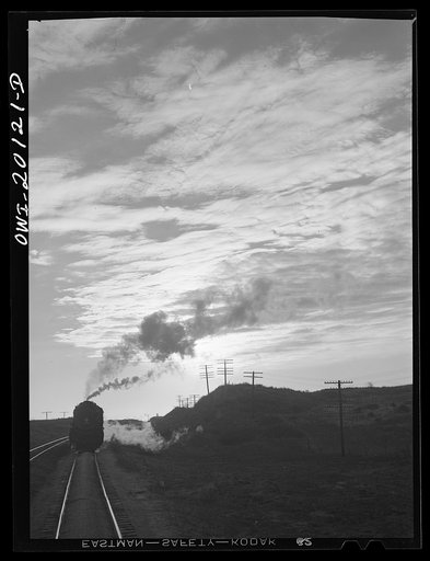 Curtis, Oklahoma. Helper engine leaving an Atchison, Topeka and Santa Fe train early in the morning after having helped push it from Belva, Oklahoma