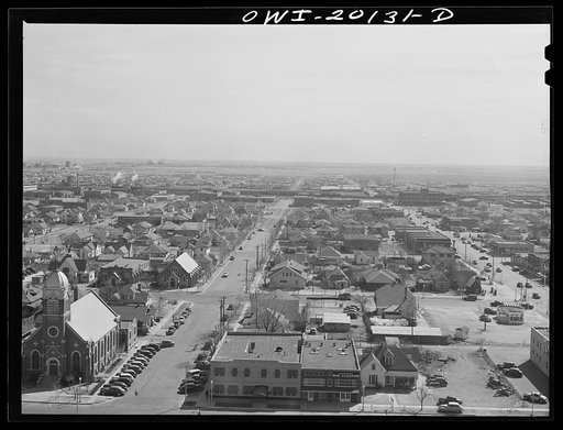 Amarillo, Texas. View over the city. The two puffs of smoke in the background (left) are from an eastbound Atchison, Topeka and Santa Fe Railroad double-header freight train. Above the smoke is a huge oil refinery