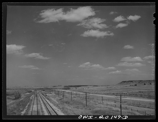 Crossing the "breaks" country of northeast Texas panhandle. Note cap-rock on hills in distance. This is the level of the plains a little farther west enroute to Amarillo, Texas on the Atchison, Topeka and Santa Fe Railroad