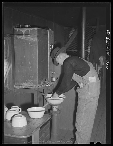 Untitled photo, possibly related to: Brakeman Jack W. Torbet of Waynoka, Oklahoma washing dishes after having had lunch in the caboose on the Atchison, Topeka and Santa Fe Railroad enroute to Canadian, Texas between Waynoka, Oklahoma and Canadian, Texas