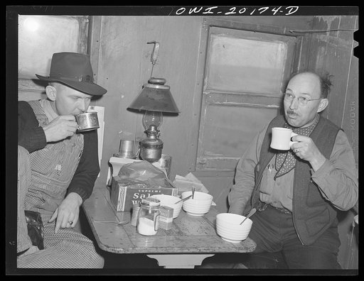 Atchison, Topeka and Santa Fe brakeman Jack W. Torbet, left, and conductor James M. Johnson having lunch in the caboose enroute to Canadian, Texas