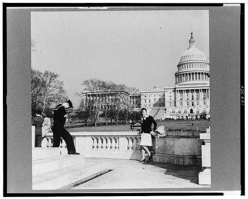 Washington, D.C. Sailor taking a picture of his girlfriend on the steps of a monument in front of the Capitol on a Sunday afternoon
