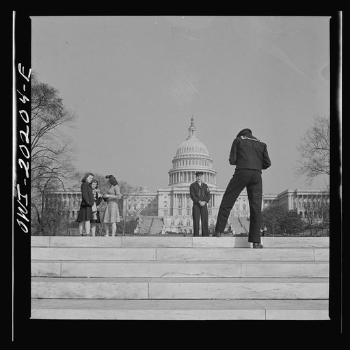 Washington, D.C. Sailor taking pictures on the steps of the National Gallery of Art on a Sunday afternoon. The Capitol is in the background