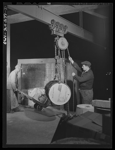 Baltimore, Maryland. Using a crane to load a drum of alcohol onto a truck at Davidson truck terminal