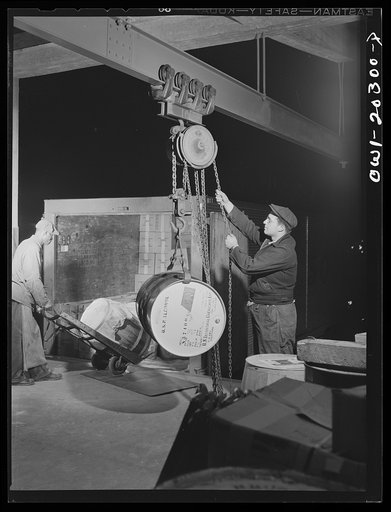 Untitled photo, possibly related to: Baltimore, Maryland. Using a crane to load a drum of alcohol onto a truck at Davidson truck terminal