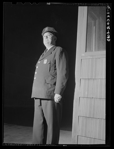 Untitled photo, possibly related to: Baltimore, Maryland. Terminal office employee showing his identification badge to the guard before entering the Davidson truck terminal