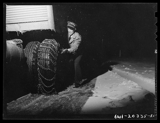Jim Fletcher putting on chains in order to get the truck across the Blue Ridge Mountains of eastern Tennessee during a snow storm