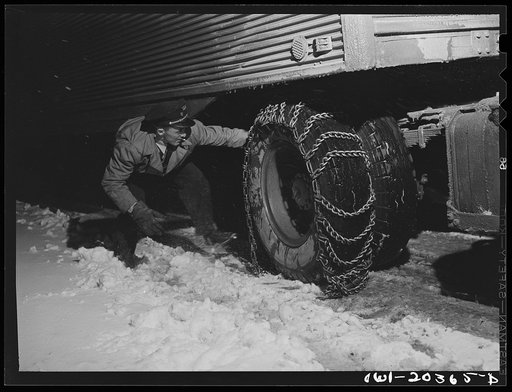 Jim Fletcher putting on chains in order to get the truck across the Blue Ridge Mountains of eastern Tennessee during a snow storm