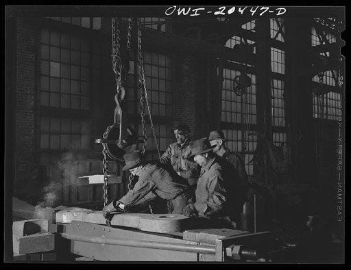 Albuquerque, New Mexico. An apparatus for shortening drawbars. The drawbar has just been taken out of the forge and is being lowered into place in the Atchison, Topeka and Santa Fe Railroad blacksmith shop