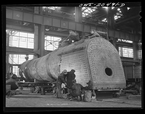 Untitled photo, possibly related to: Albuquerque, New Mexico. Working on the fire box of an engine in the Atchison, Topeka and Santa Fe Railroad locomotive shops