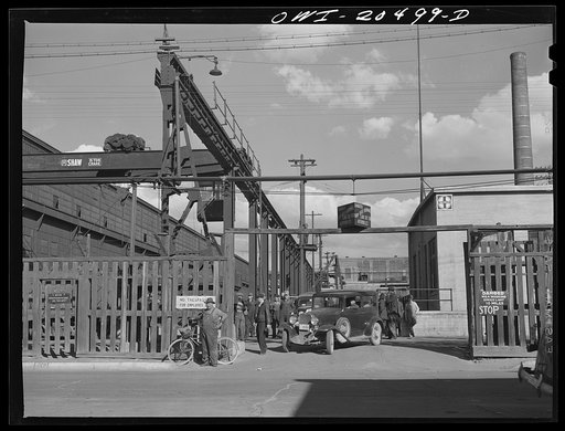 Albuquerque, New Mexico. Workmen coming out of the Atchison, Topeka and Santa Fe Railroad locomotive shops at the end of the day's shift