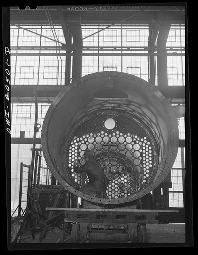 Albuquerque, New Mexico. Workmen making inspection of newly-driven rivets in a flue sheet and boiler seam in the Atchison, Topeka and Santa Fe Railroad locomotive shops