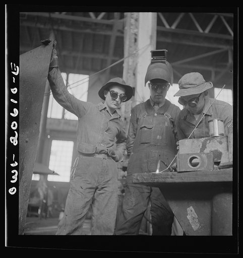 Untitled photo, possibly related to: Clovis, New Mexico. Soldiers of the United States Army Railroad Battalion study welding at the locomotive ships in the Atchison, Topeka and Santa Fe Railroad. Left to right: Private Edward Dravis of Minnesota; Earl Weidinger, instructor and welder; and Sergeant A