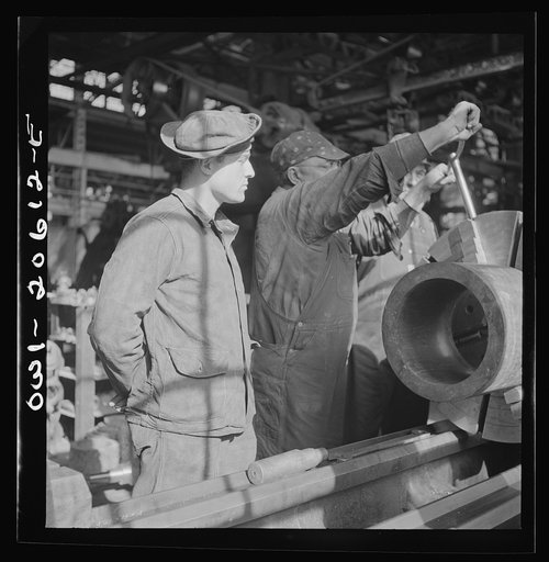 Untitled photo, possibly related to: Clovis, New Mexico. A machinist in the Atchison, Topeka and Santa Fe Railroad locomotive shops, John Corey, working at an engine lathe making steel bushing with Sergeant Bowman of the United States Army Railroad Battalion who is stationed at Clovis