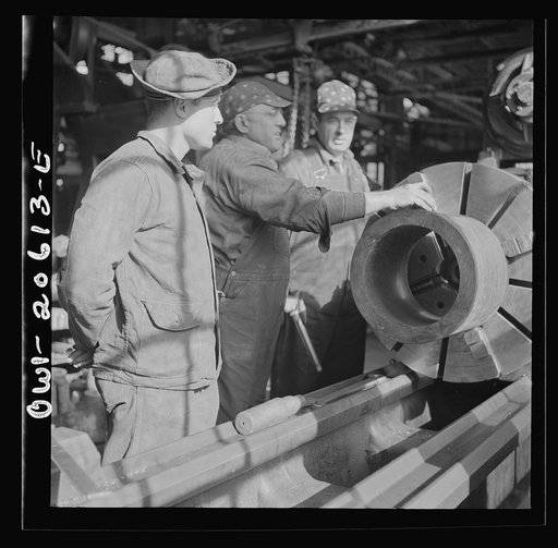 Untitled photo, possibly related to: Clovis, New Mexico. A machinist in the Atchison, Topeka and Santa Fe Railroad locomotive shops, John Corey, working at an engine lathe making steel bushing with Sergeant Bowman of the United States Army Railroad Battalion who is stationed at Clovis