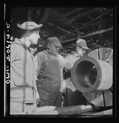 Clovis, New Mexico. A machinist in the Atchison, Topeka and Santa Fe Railroad locomotive shops, John Corey, working at an engine lathe making steel bushing with Sergeant Bowman of the United States Army Railroad Battalion who is stationed at Clovis