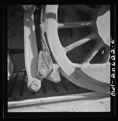 Clovis, New Mexico. Refacing the tires of a locomotive with a Ledgerwood apparatus. The locomotive is drawn down the rails by a cable, while cutting edges inserted in the brake shoes does the refacing in the Atchison, Topeka and Santa Fe Railroad shops