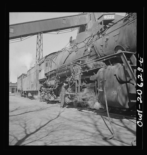 Clovis, New Mexico. Refacing the tires of a locomotive with a Ledgerwood apparatus. The locomotive is drawn down the rails by a cable, while cutting edges inserted in the brake shoes does the resurfacing in the Atchison, Topeka and Santa Fe Railroad shops