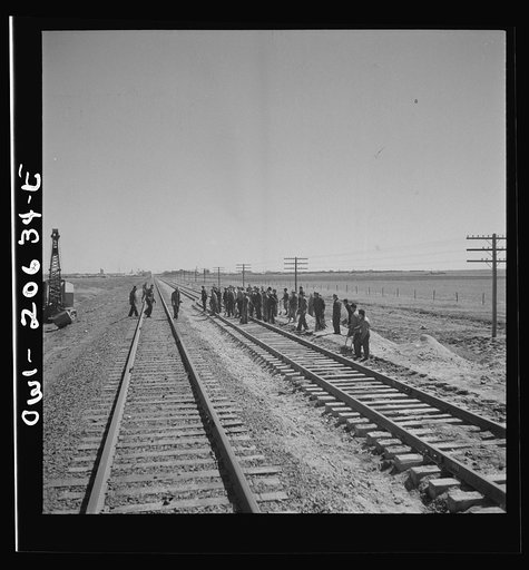 Untitled photo, possibly related to: Clovis, New Mexico. Passing a section gang at work on the outskirts along the Atchison, Topeka, and Santa Fe Railroad between Clovis and Vaughn, New Mexico