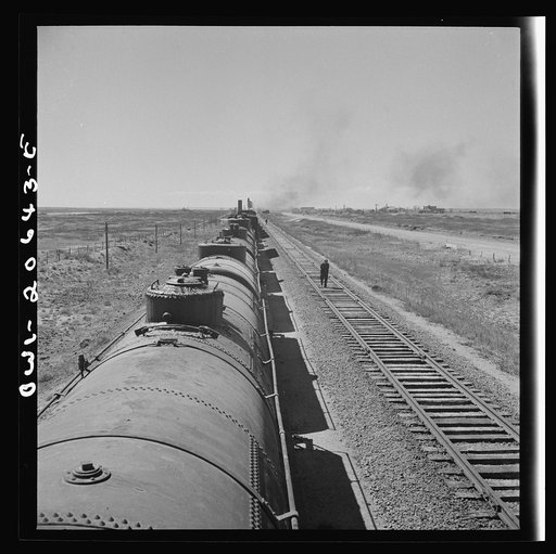 Tolar, New Mexico. Atchison, Topeka, and Santa Fe Railroad train between Clovis and Vaughn, New Mexico stopping for water. A brakeman walking the length of the train for inspection