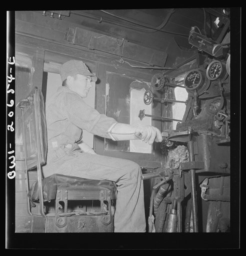 Ricardo, New Mexico. Fireman C.P. Fryer in his cab on the Atchison, Topeka, and Santa Fe Railroad, between Clovis and Vaughn, New Mexico