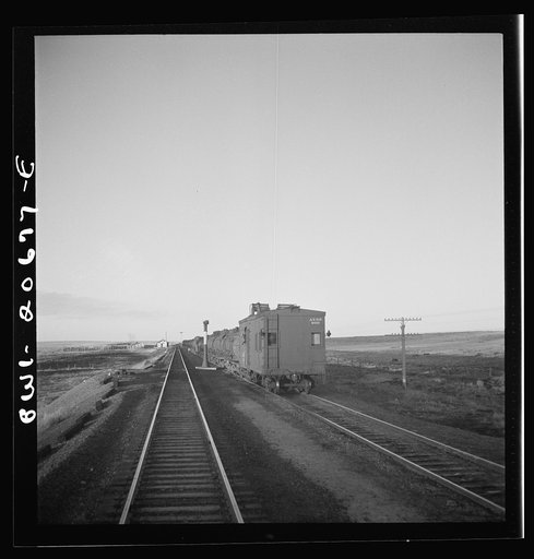 Duors, New Mexico. Passing a water train along the Atchison, Topeka, and Santa Fe Railroad between Clovis and Vaughn, New Mexico. The railroad has no well water between Vaughn and Ricardo, New Mexico. This train delivers thirty cars of water daily at stations between Vaughn and Ricardo, New Mexico. 