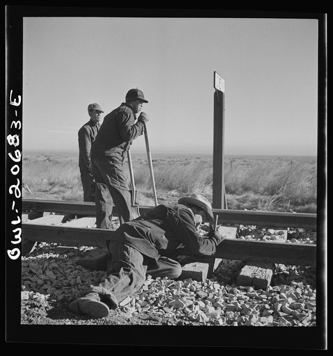 Iden, New Mexico. Section gang raising, surfacing and gauging the track in the Atchison, Topeka and Santa Fe Railroad yard. Assistant foreman is lining the track between Clovis and Vaughn, New Mexico