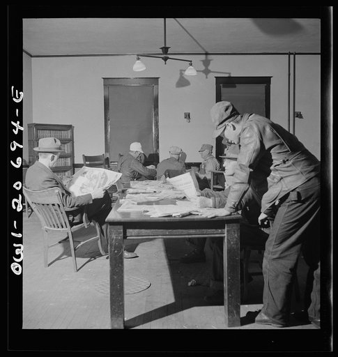 Vaughn, New Mexico. Railroad men reading newspapers and playing dominoes in the Atchison, Topeka and Santa Fe Railroad yard reading room