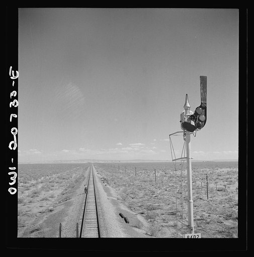 Willard, New Mexico. Flagman walks back to flag any oncoming trains his train stops for water between Vaughn and Belen, New Mexico on the Atchison, Topeka and Santa Fe Railroad