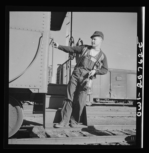 Belen, New Mexico. A brakeman on the Atchison, Topeka and Santa Fe Railroad C.G. Kirkland getting off the caboose