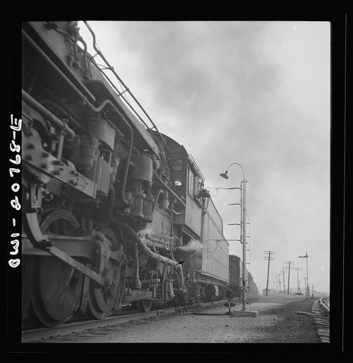 Isleta, New Mexico. Fireman of a passing freight train on the Atchison, Topeka and Santa Fe Railroad picking up a message. The lower hoop is for the conductor at the rear end
