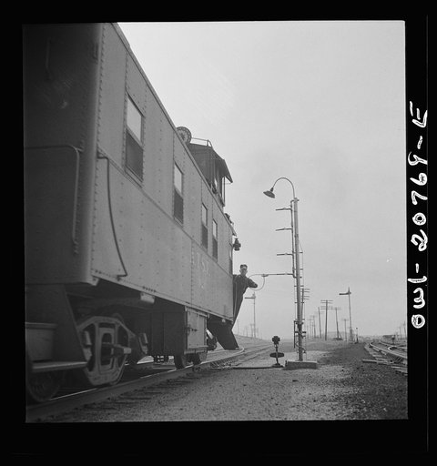 Isleta, New Mexico. Conductor of a passing freight train on the Atchison, Topeka and Santa Fe Railroad picking up a message