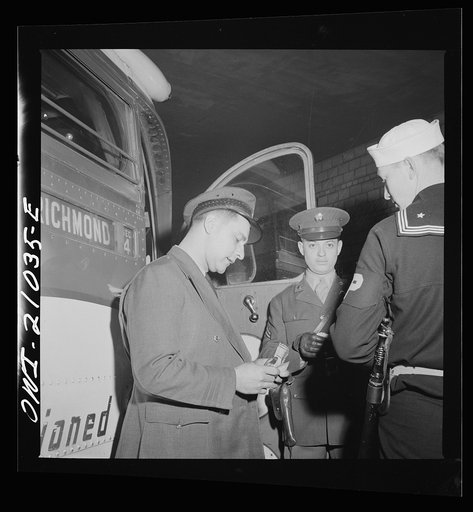 Washington, D.C. Driver checking ticket of a soldier who is entering the bus at the Greyhound terminal