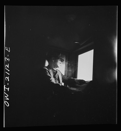 Untitled photo, possibly related to: Conductor J.R. Crawford, watching the train from his window in the cupola of the caboose along the Atchison, Topeka, and Santa Fe Railroad between Canadian and Amarillo, Texas