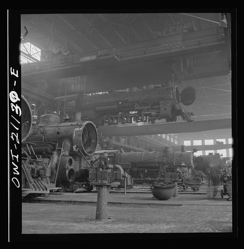 Untitled photo, possibly related to: Albuquerque, New Mexico. An engine being carried to another part of the Atchison, Topeka and Santa Fe Railroad shops to be wheeled