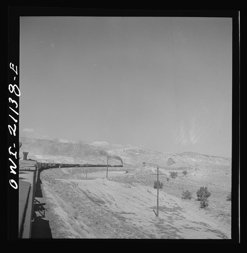 Untitled photo, possibly related to: Quirk (vicinity), New Mexico. A train rounding a curve along the Atchison, Topeka and Santa Fe Railroad between Belen and Gallup, New Mexico