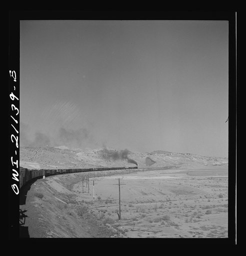 Untitled photo, possibly related to: Quirk (vicinity), New Mexico. A train rounding a curve along the Atchison, Topeka and Santa Fe Railroad between Belen and Gallup, New Mexico