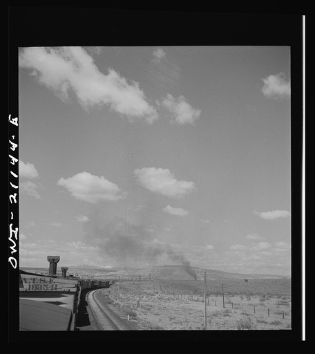 Untitled photo, possibly related to: Quirk (vicinity), New Mexico. A train rounding a curve along the Atchison, Topeka and Santa Fe Railroad between Belen and Gallup, New Mexico