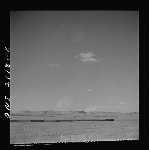 South Chaves (vicinity), New Mexico. On the Atchison, Topeka and Santa Fe Railroad between Belen and Gallup, New Mexico, passing an eastbound passenger train