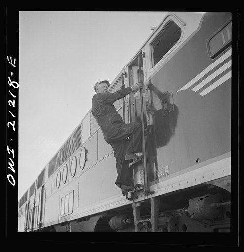 Winslow, Arizona. An engineer climbing into the cab of a diesel freight engine in the Atchison, Topeka and Santa Fe Railroad yard