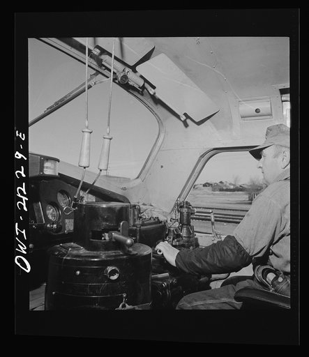 Untitled photo, possibly related to: Winslow, Arizona. Engineer George Bertino in the cab of his diesel freight engine, ready to pull out of the Atchison, Topeka and Santa Fe Railroad yard