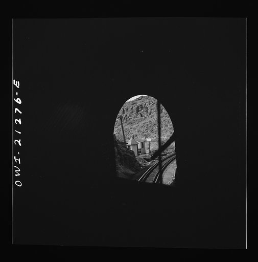 Williams (vicinity), Arizona. A train on the Atchison, Topeka and Santa Fe Railroad between Winslow and Seligman, Arizona coming out of a tunnel through the hillside