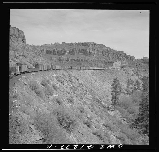 Williams (vicinity), Arizona. A train on the Atchison, Topeka and Santa Fe Railroad between Winslow and Seligman, Arizona coming out of a tunnel through the hillside