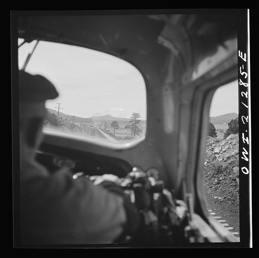 Untitled photo, possibly related to: Willliams, Arizona. The engineer, on the Atchison, Topeka and Santa Fe Railroad between Winslow and Seligman, Arizona, with his hand on the "air" as the train slows down