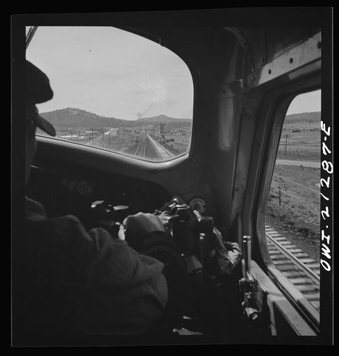 Willliams, Arizona. The engineer, on the Atchison, Topeka and Santa Fe Railroad between Winslow and Seligman, Arizona, with his hand on the "air" as the train slows down