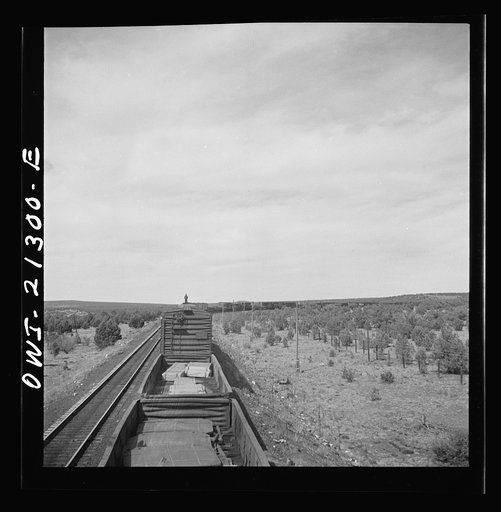 Untitled photo, possibly related to: A diesel freight train on the Atchison, Topeka and Santa Fe Railroad between Winslow and Seligman, Arizona going down the mountains from Supai to Ash Fork, Arizona, a drop of about 1600 feet. A brakeman is riding on the top of the car. He stays on as far as Ash F