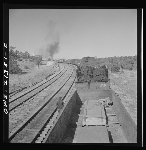Untitled photo, possibly related to: Yampai, Arizona. Brakeman and the conductor inspecting the train during a stop on the Atchison, Topeka, and Santa Fe Railroad between Seligman, Arizona and Needles, California